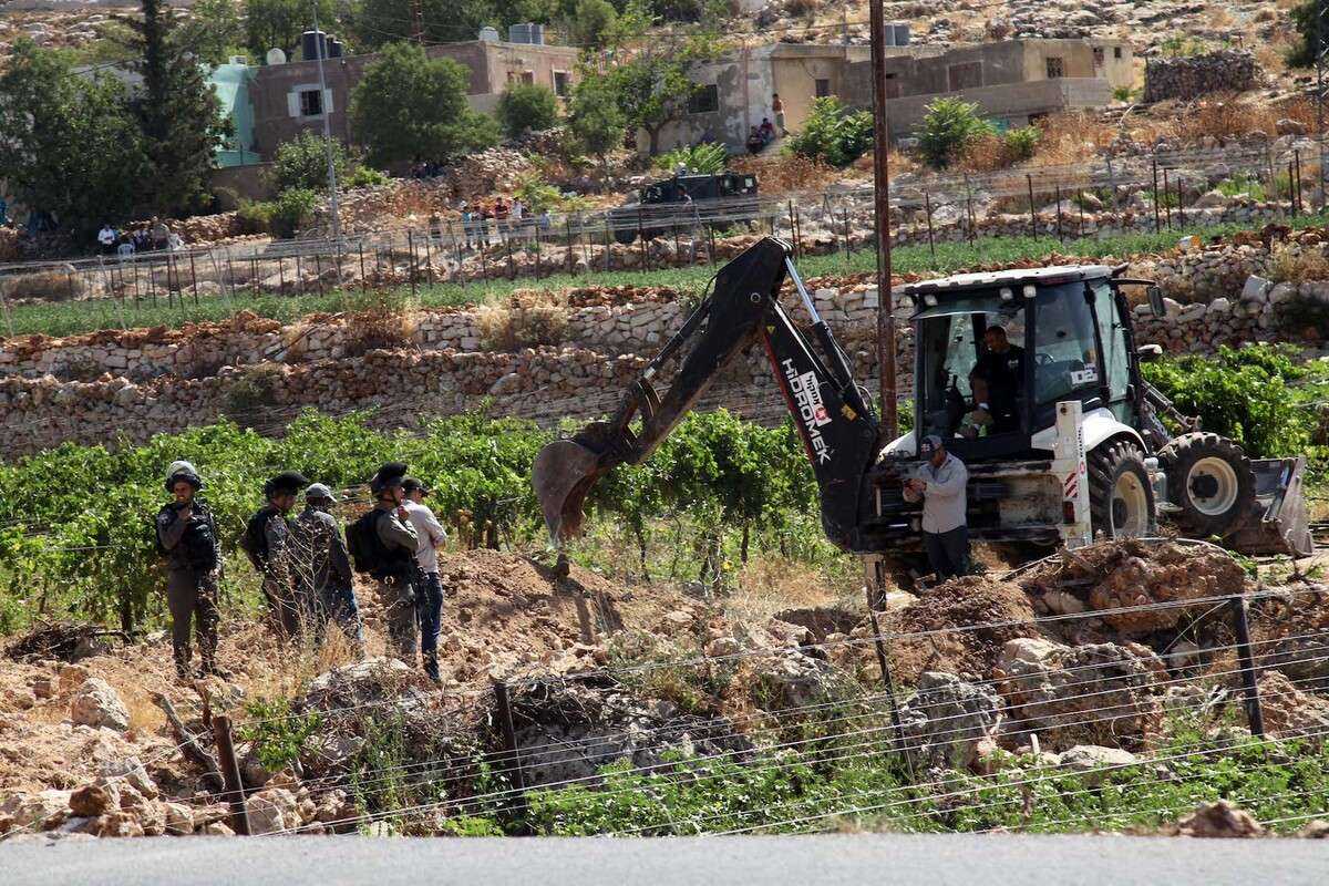 الاحتلال يجرف أرضا ويهدم جدارا في بلدة سلوان