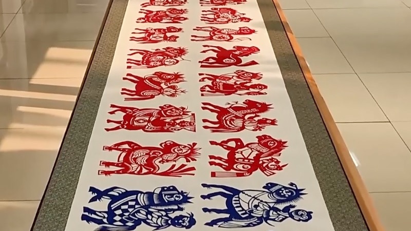 وريثة التراث الثقافي غير المادي تصمم عملا فنيا عن طريق قص الورق بطول 15 مترا بعنوان "لوحة المئة حصان" احتفالا بعيد الربيع
