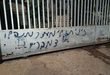 مستوطنون يهاجمون منزلا في دير نظام ويحرقون مركبة ويخطون شعارات عنصرية