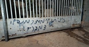 مستوطنون يهاجمون منزلا في دير نظام ويحرقون مركبة ويخطون شعارات عنصرية