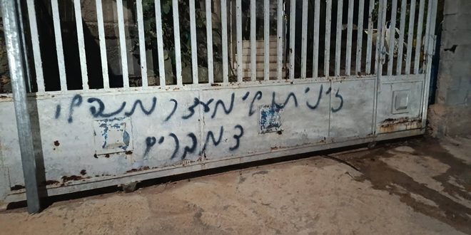 مستوطنون يهاجمون منزلا في دير نظام ويحرقون مركبة ويخطون شعارات عنصرية